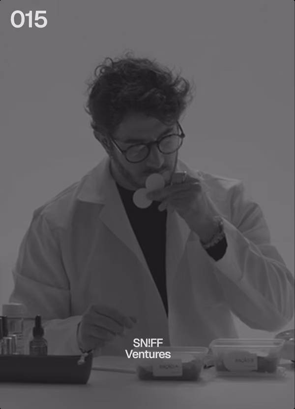 !F card 015: SN!FF, ventures. A perfumer in a lab coat smelling a test strip.